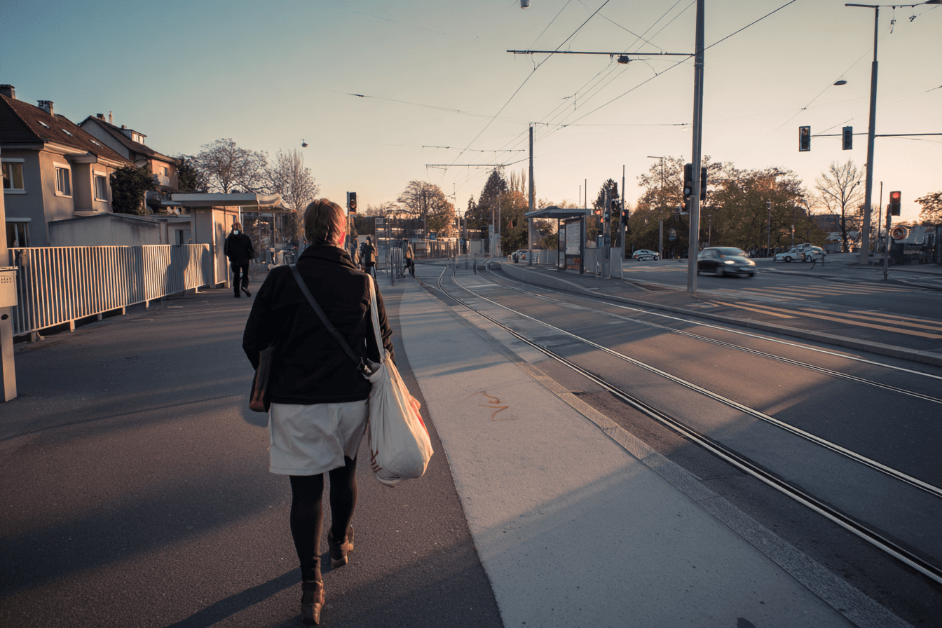 Woman at tram stop: daily life of a domestic worker